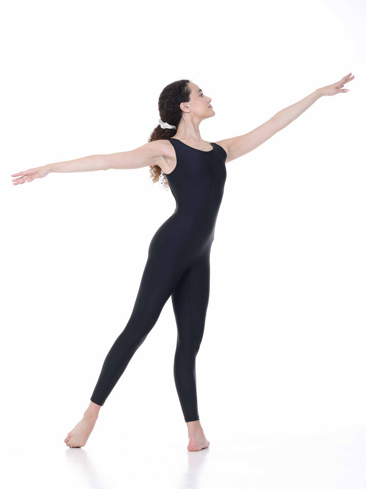 Danseuse portant le maillots intégral Sway – modèle Circular Back Tank Dance Unitard en negro, exécutant une pose de ballet avec les bras levés, sur fond blanco.