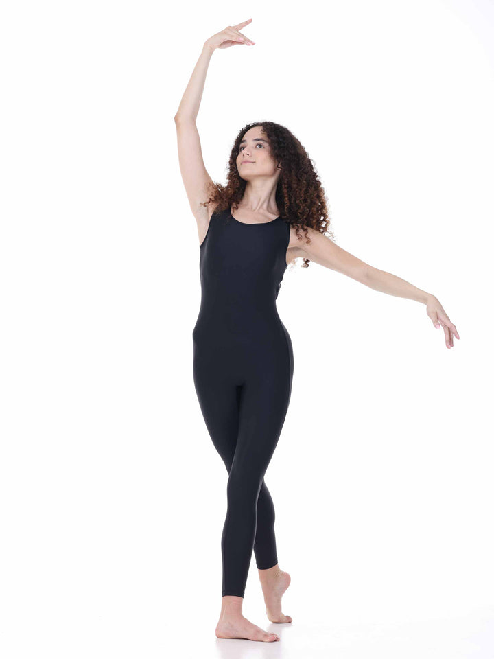 Danseuse portant un maillots intégral negro à dos rond ajouré, en position de ballet sur fond blanco.