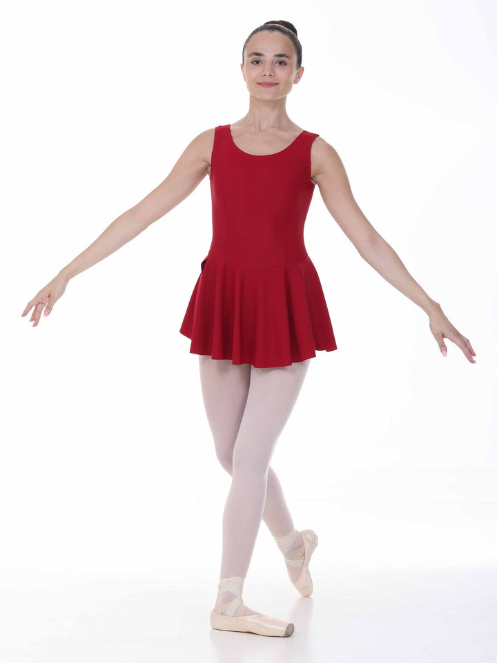 Danseuse en pose classique avec une dress de danse bordeaux – skirt flowing et maintien comfortable.
