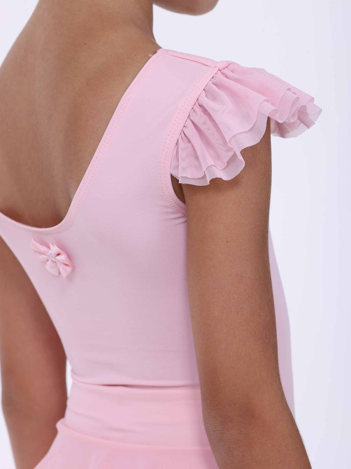 Détail du dos di la abito di danse rosa clair – petit nœud e manches à volants légers.