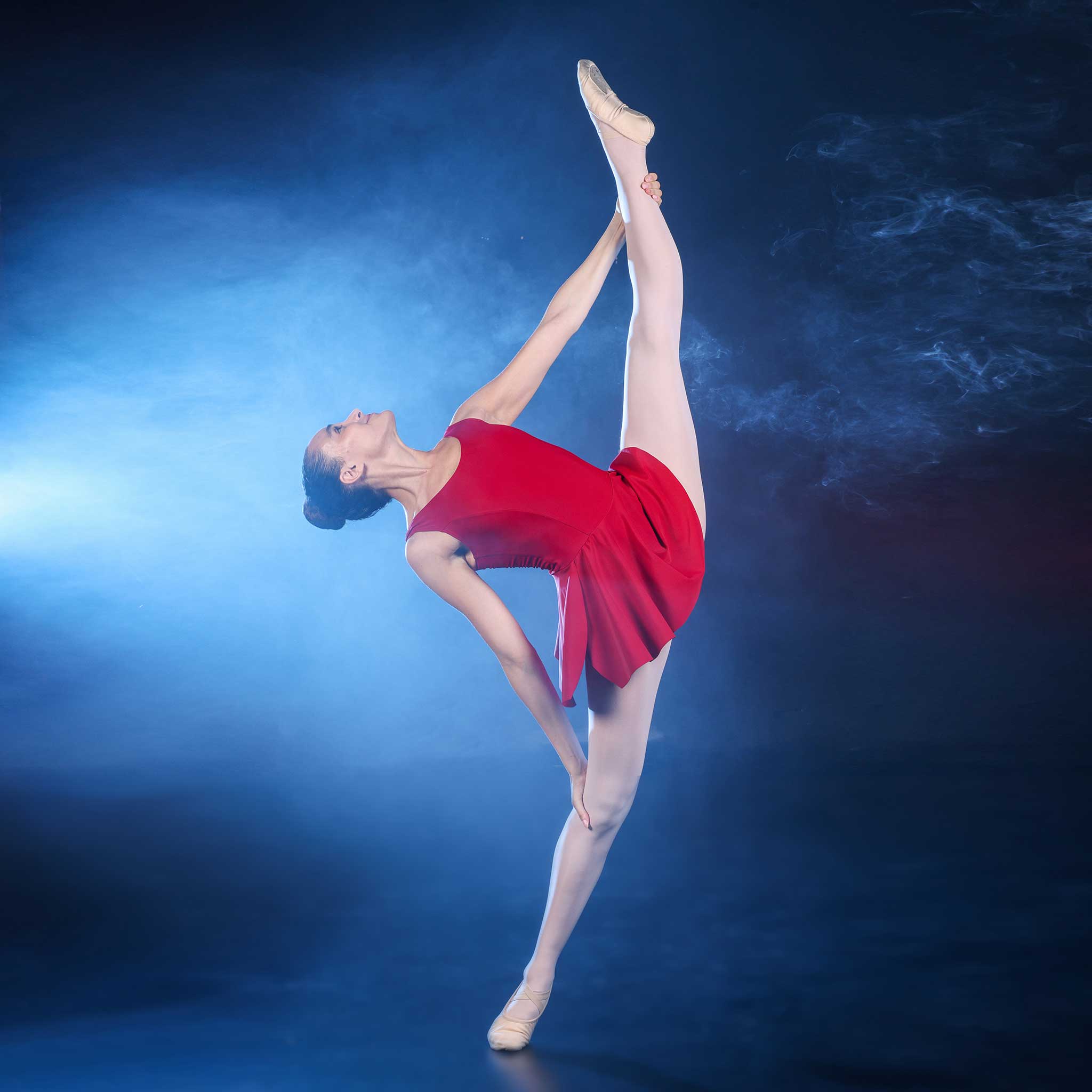 Balletttänzerin in einem roten Tanzkleid, die die rote Tanzbekleidung-Kollektion von Sway repräsentiert.